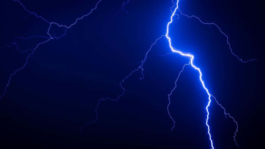 Striking Blue Lightning Against A Grey Sky Wallpaper