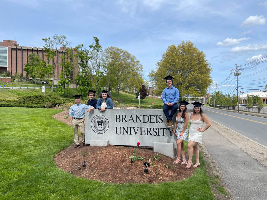 Students On Brandeis University Signage Wallpaper