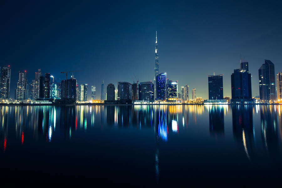 Stunning City Night Skyline Reflecting On Ocean Wallpaper