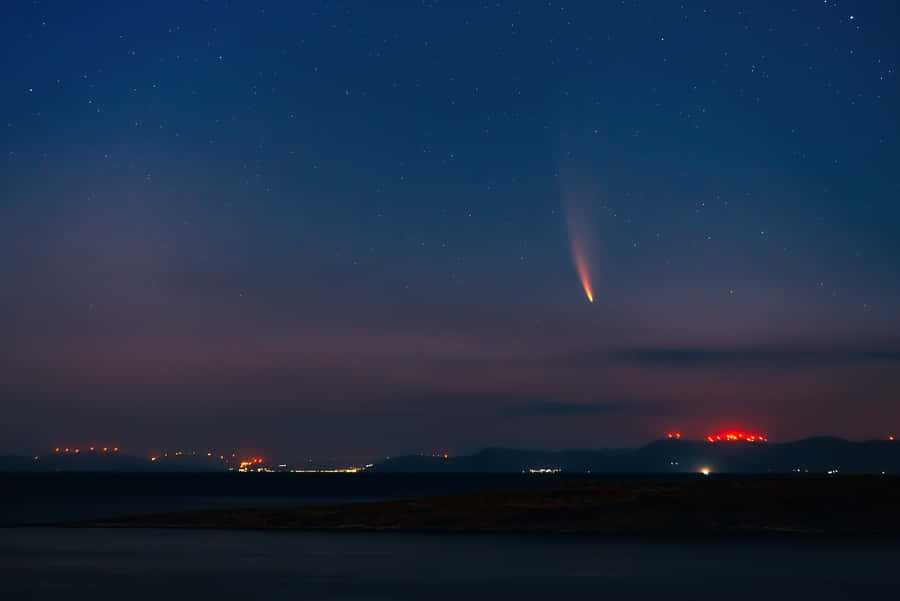 Stunning Cosmic Comet Illuminating The Night Sky Wallpaper