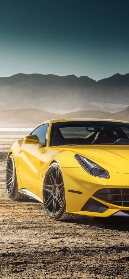 Stunning Ferrari F12 Powering Through Desert Landscape On An Iphone Background Wallpaper