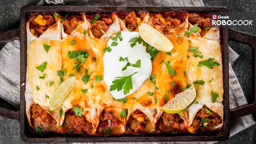 Sumptuous Tray Of Enchiladas Garnished With Fresh Limes Wallpaper