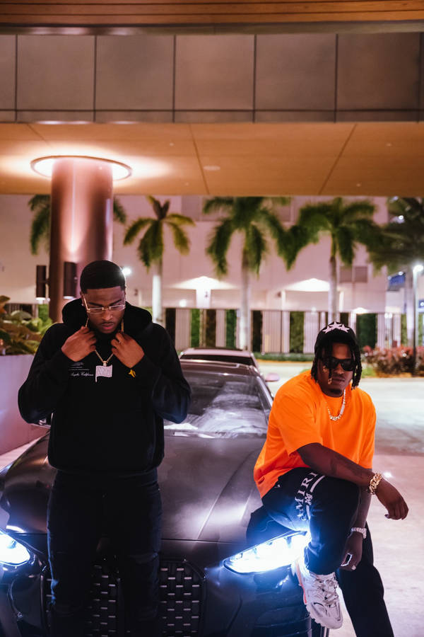 Swavy Lee Posing With His Lamborghini And Friend Wallpaper