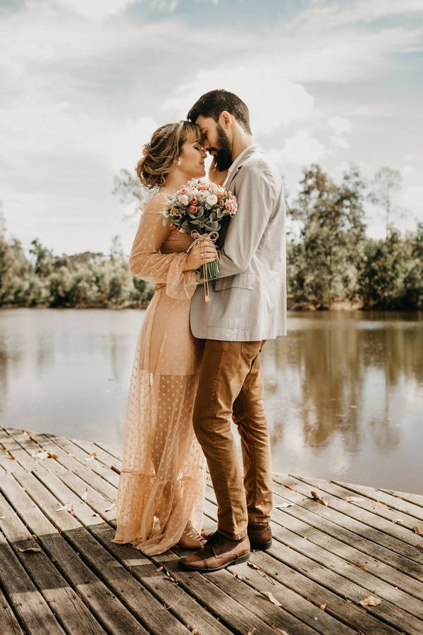 Sweet Married Couple Hugging By The River Wallpaper