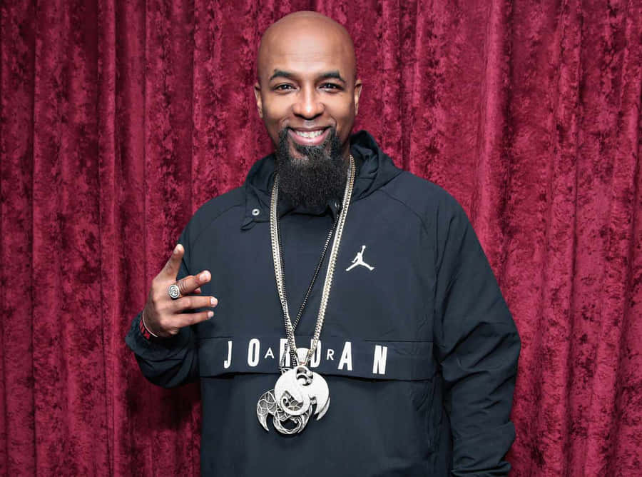 Tech N9ne Smiling Against Red Backdrop Wallpaper