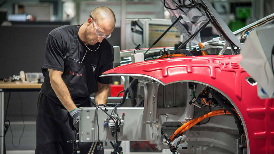 Technician Assembling Car Tesla Factory Wallpaper