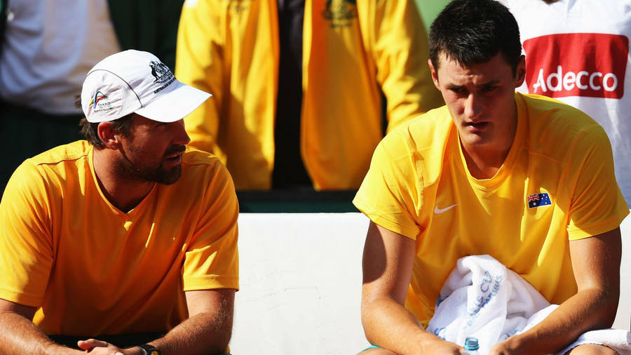 Tennis Legends - Patrick Rafter And Bernard Tomic In Candid Discussion On The Court Wallpaper