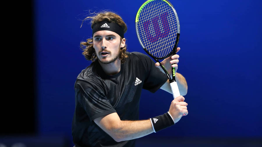 Tennis Star Stefanos Tsitsipas With Racket In Action Wallpaper