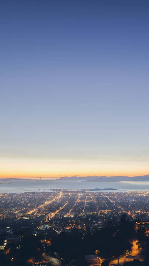 The City Draped In The Golden Glow Of The Setting Sun Wallpaper