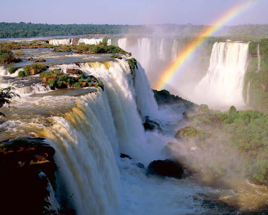 The Majestic Iguazu Falls Embraced By A Stunning Rainbow Wallpaper