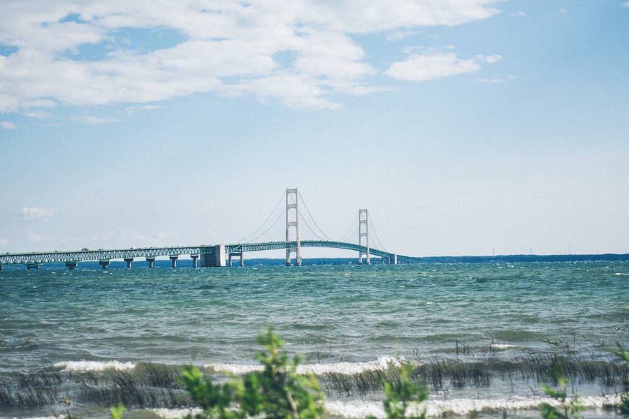 The Majestic Mackinac Bridge Stretching Across The Serene Blue Waters Wallpaper