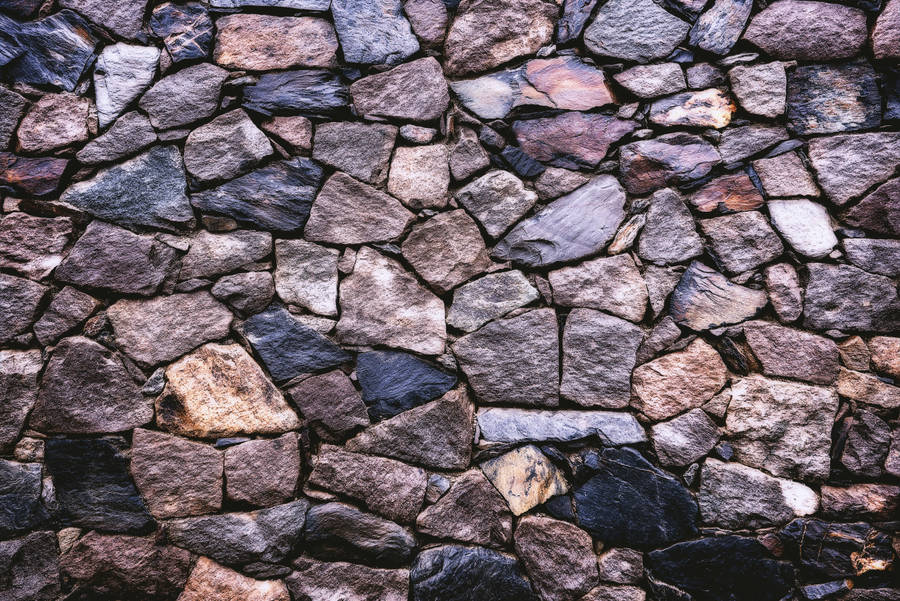 The Vibrant Palette Of A Stone Wall, Abundantly Rich In Color And Texture. Wallpaper