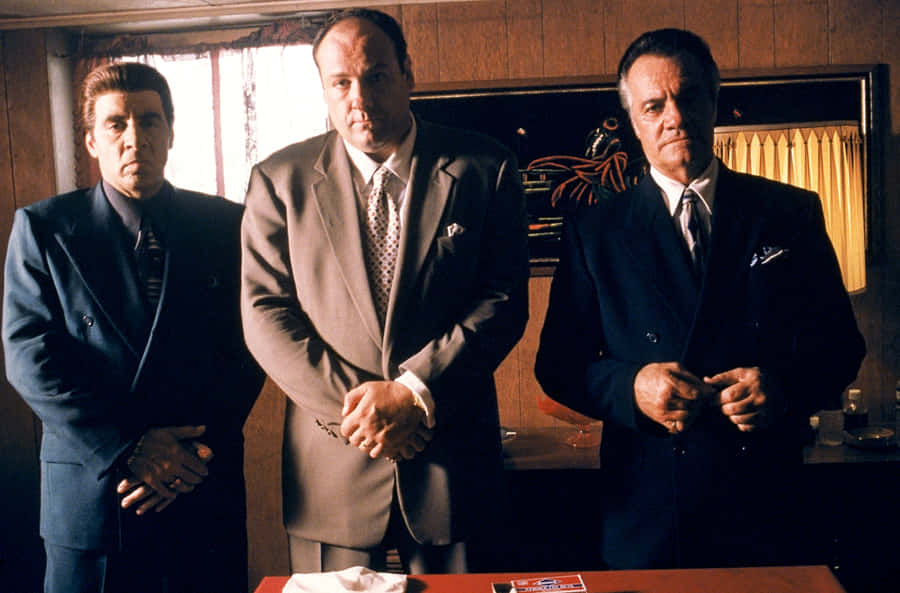 Three Men Standing In Front Of A Table Wallpaper