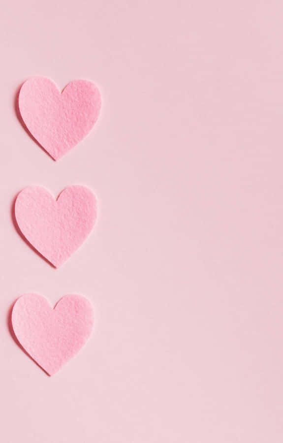 Three Pink Heart Shaped Paper On A Pink Background Wallpaper