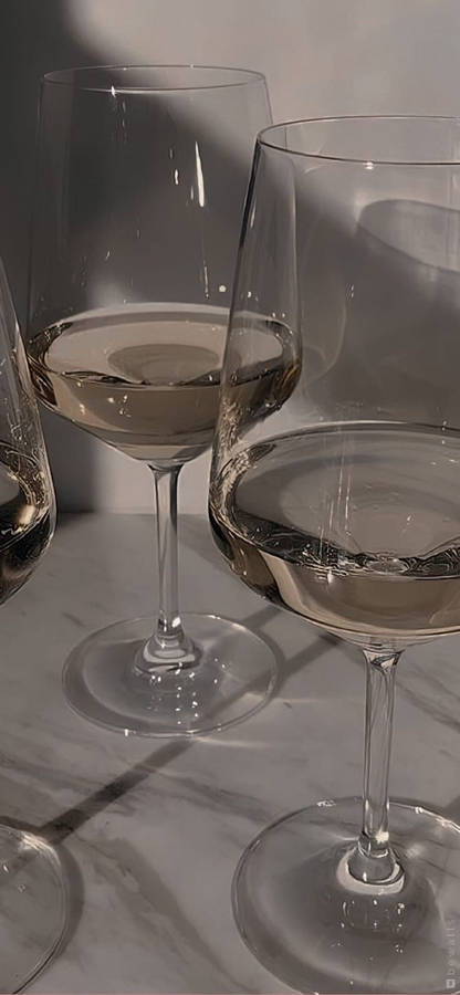 Three Wine Glasses On A Marble Surface Wallpaper