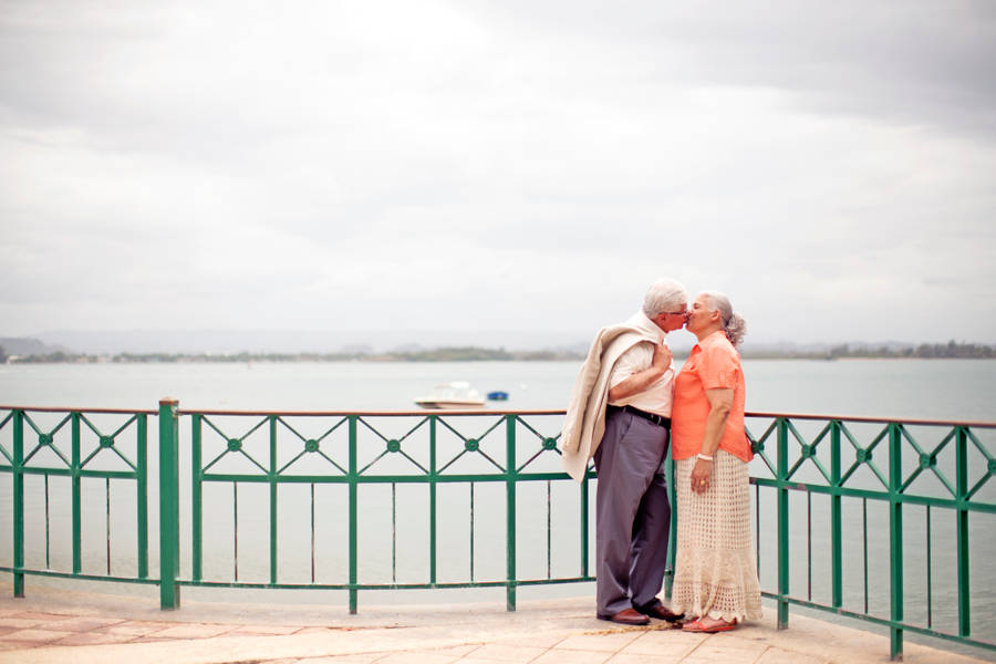 Timeless Love: An Elderly Couple In A Romantic Embrace Wallpaper