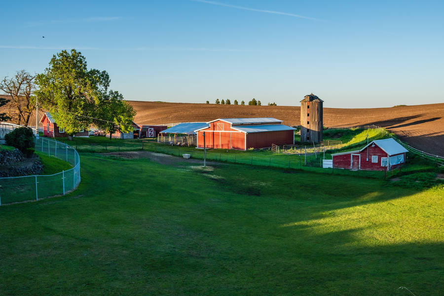 Tranquil Countryside Farm With Numerous Structures Wallpaper