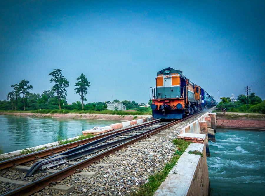 Tranquil Train Journey By The River Wallpaper