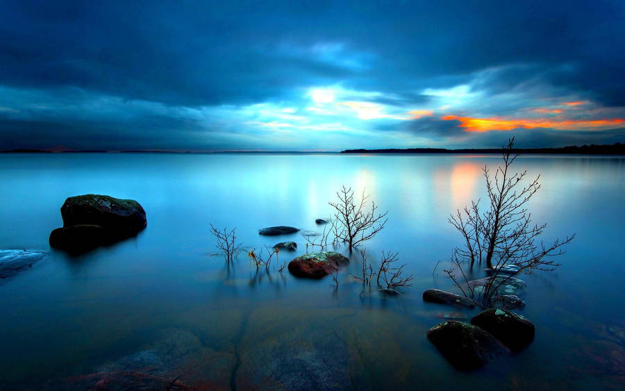 Tranquil Water Under The Dark Clouds Horizon Wallpaper