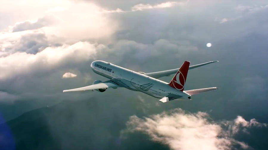 Turkish Airlines Majestic Flight Over The Turquoise Ocean Wallpaper