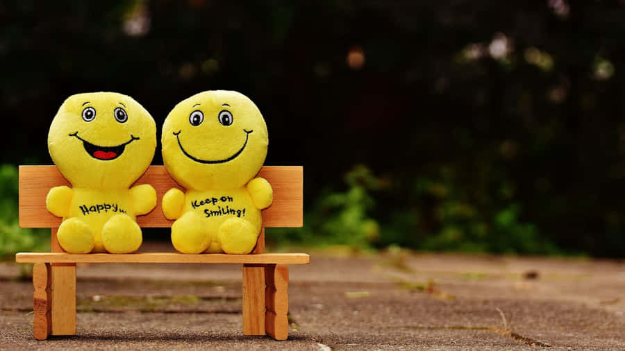 Two Stuffed Animals Sitting On A Wooden Bench Wallpaper