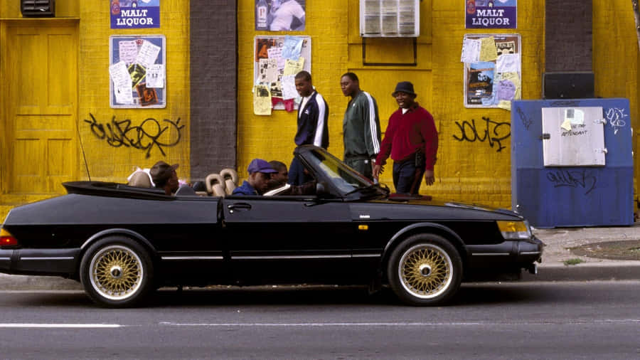 Urban Street Scene With Classic Car And People Wallpaper