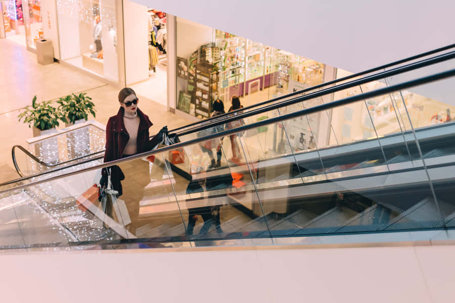 Vain Woman Going Up The Escalator Wallpaper