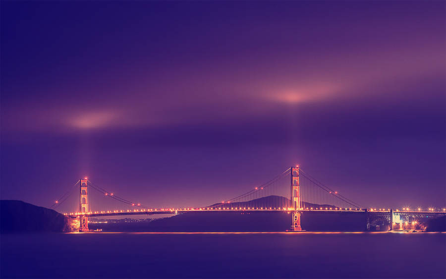 Vibrant Golden Gate Bridge Illuminated At Night Wallpaper