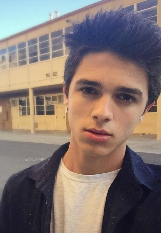 Vibrant Photo Of Brent Rivera Leaning Against A Building. Wallpaper