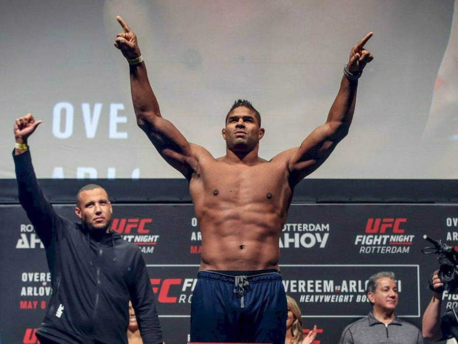 Victorious Alistair Overeem Raising His Hands High Wallpaper