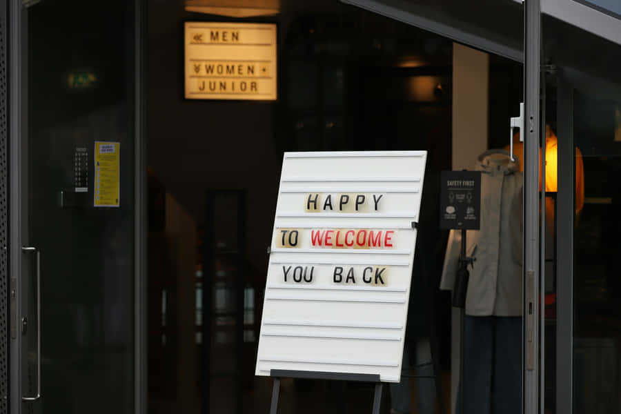 Welcome Back Sign Outside Store Wallpaper