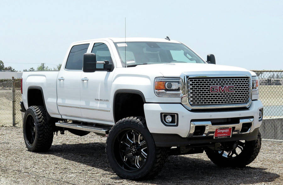 White Gmc In Fenced Area Wallpaper