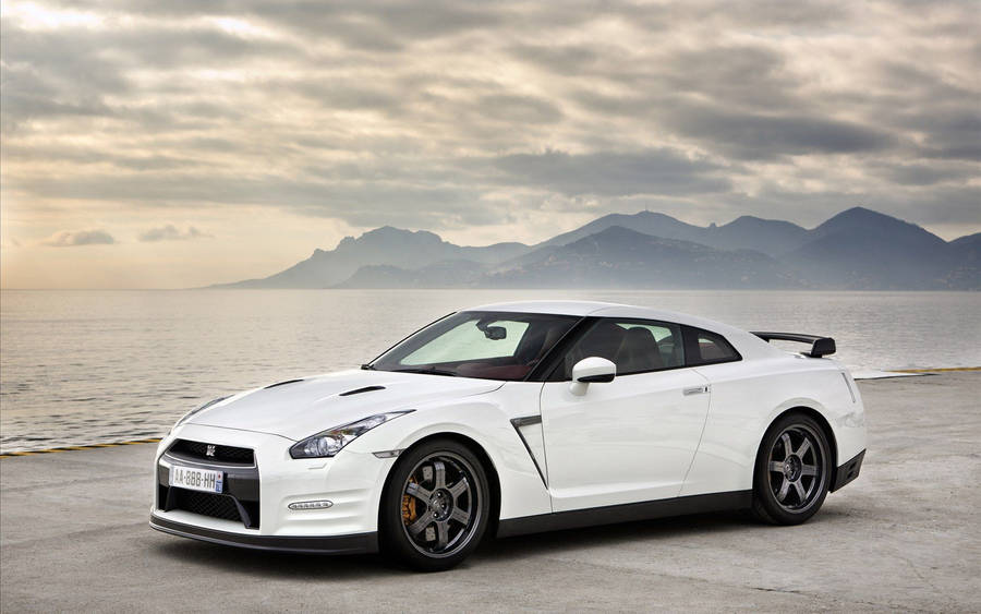 White Nissan Gtr Car Alongside A Seashore Wallpaper