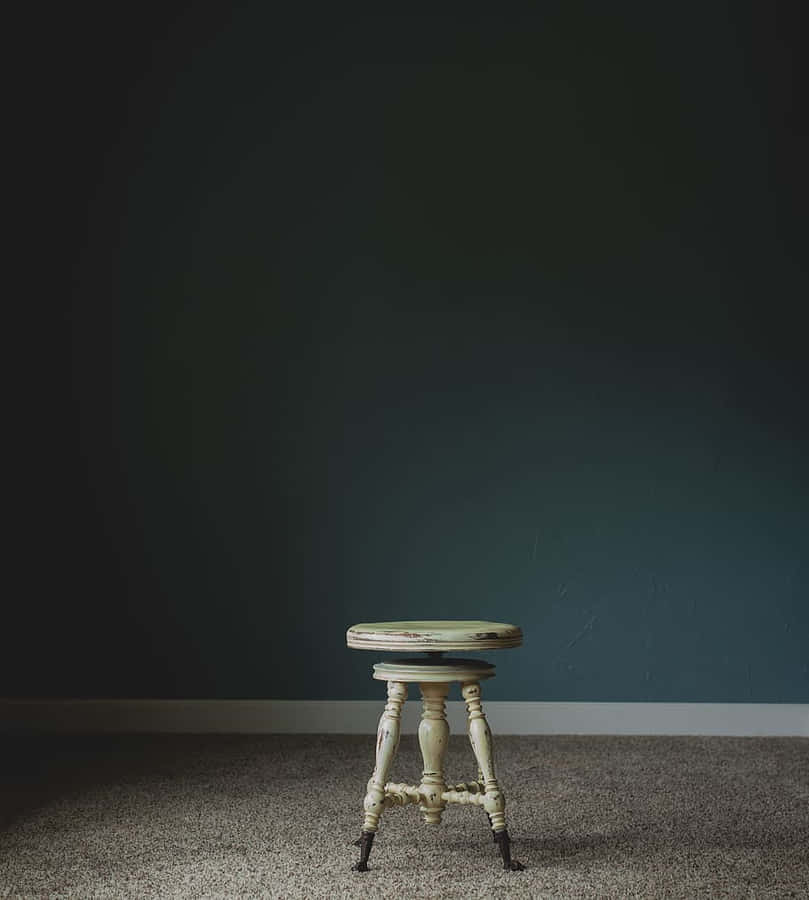 White Wooden Stool Chair In Dark Room Wallpaper