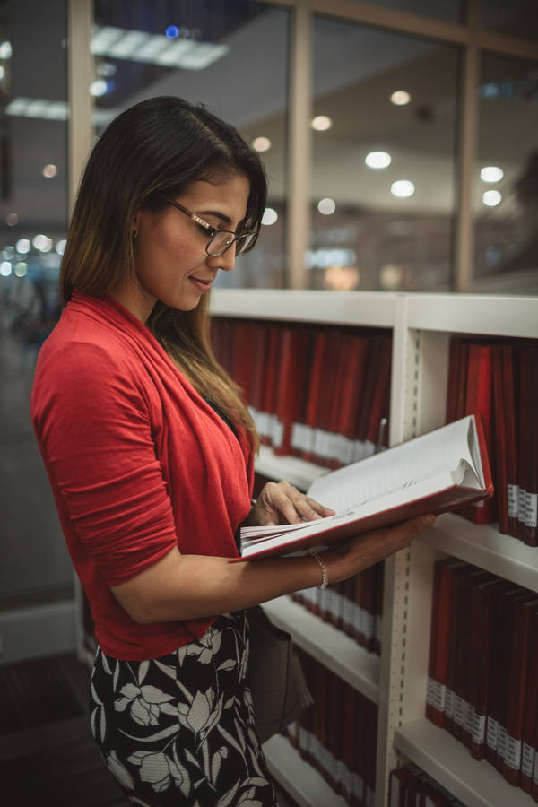 Woman Reading A Reference Book Wallpaper