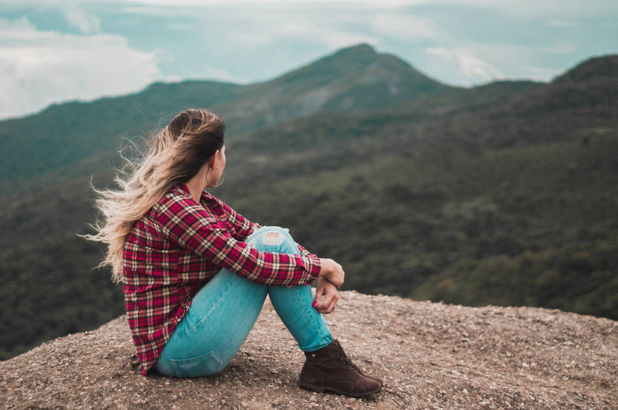 Woman Sitting Alone Near A Cliff Wallpaper