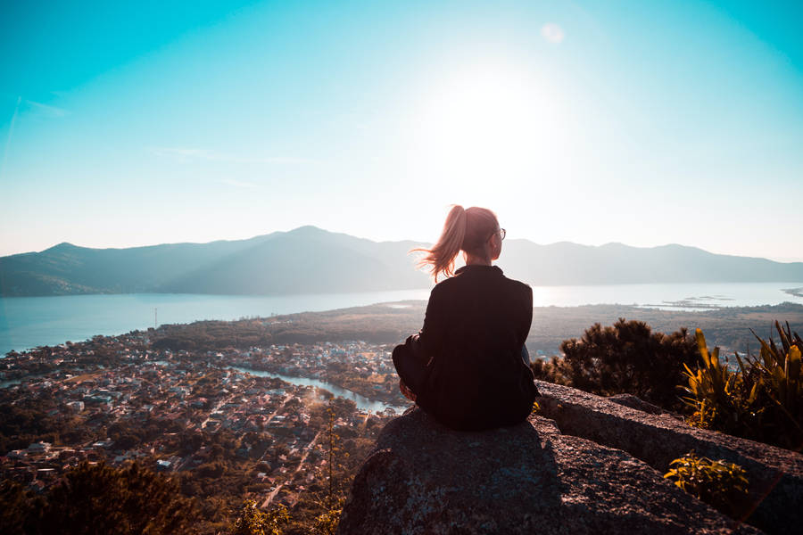 Woman Sitting Alone On Rock Wallpaper