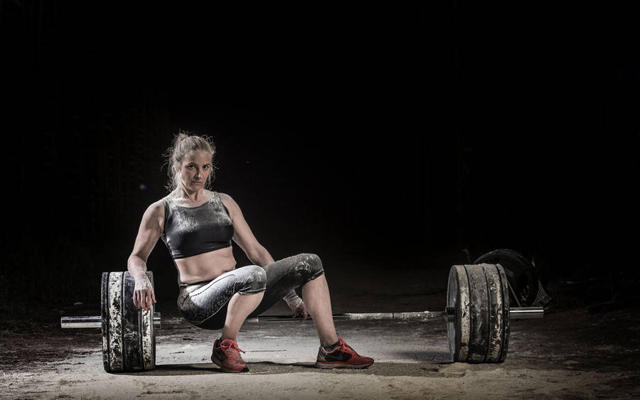 Woman Sitting On Barbell Wallpaper