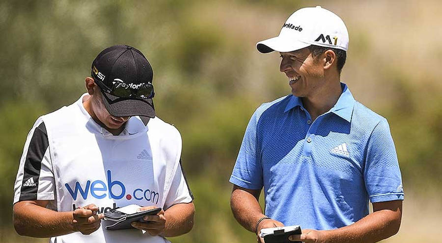 Xander Schauffele Evaluating The Next Move On The Golf Course With A Colleague Wallpaper