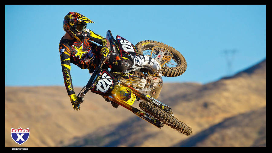 Yellow Dirt Bike In Action Wallpaper