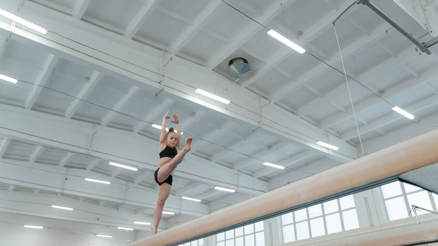 Young Girl Balancing On Balance Beam Wallpaper