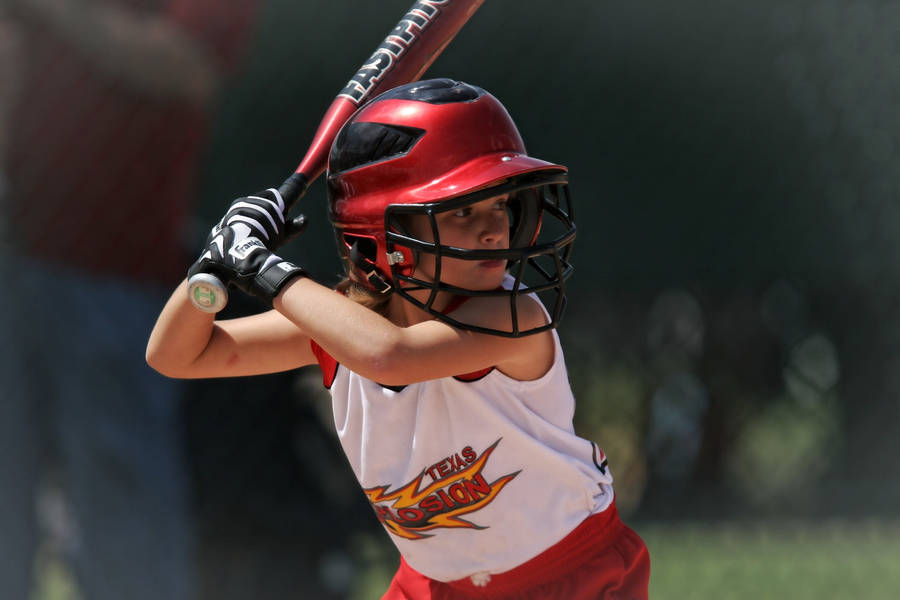 Young Softball Player Holding Bat Wallpaper