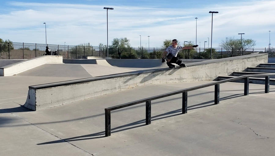 Youthful Enthusiasm: Boy Rollerblading At Skate Park Wallpaper