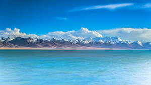 2560 X 1440 Mountain Range By The Sea Wallpaper