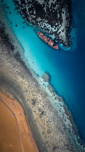 4k Iphone Aerial View Ship On Beach Wallpaper