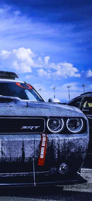 A Black And Gray Car Is Parked In A Parking Lot Wallpaper