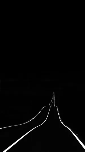 A Black And White Photo Of A Road With Lights Wallpaper