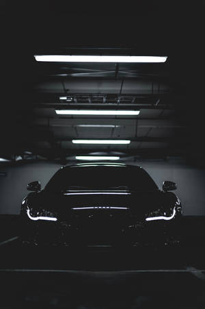 A Black Car In A Dark Parking Garage Wallpaper
