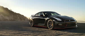 A Black Sports Car Is Parked On A Rocky Road Wallpaper