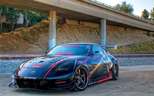 A Black Sports Car Parked Under A Bridge Wallpaper